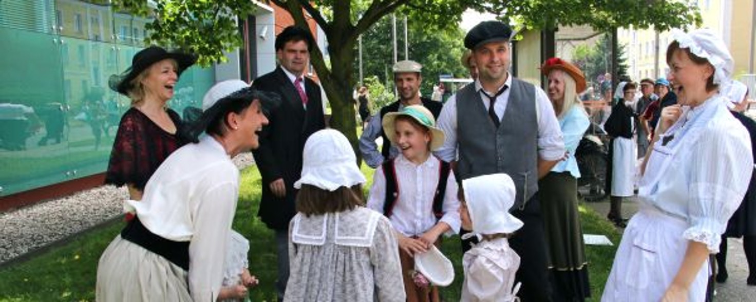 Eine Gruppe in altertümlicher Kleidung Menschen stehen zusammen und lachen