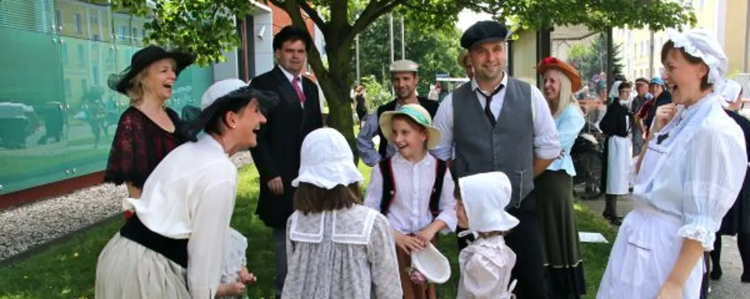 Eine Gruppe in altertümlicher Kleidung Menschen stehen zusammen und lachen