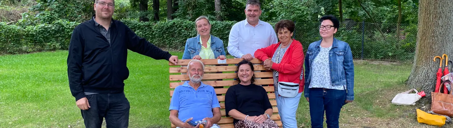 Eine Gruppe von Menschen weiht eine neue, schattige Sitzbank für ältere Menschen im Freibad der Stadt Forst ein.
