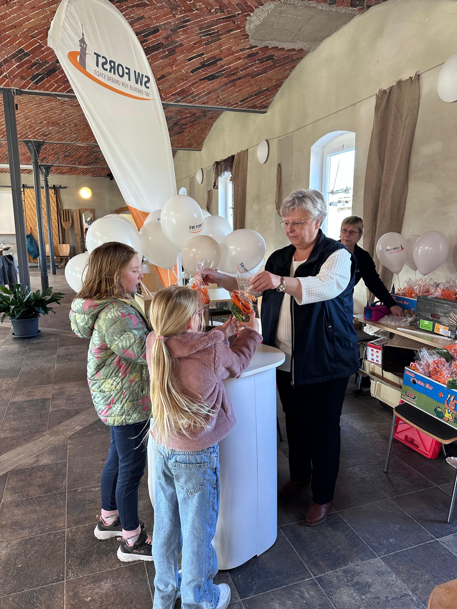 Kinder erhalten eine Ostertüte mit Süßigkeiten am SW Forst Stand
