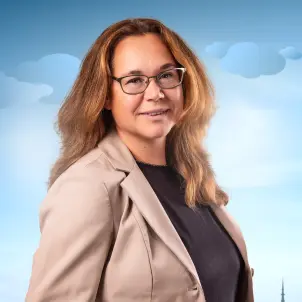 Silke Goldschmidt, Vertriebsleiterin und Prokuristin, trägt Anzug und Hemd und lächelt in die Kamera