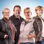 Drei Frauen und ein Mann stehen nebeneinander und lächeln in die Kamera